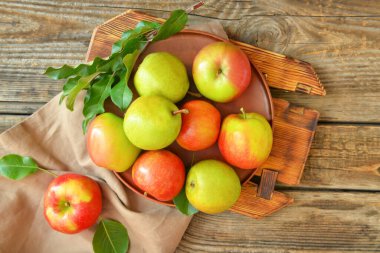 Ahşap arka planda lezzetli elma ve armut meyveli tabak.