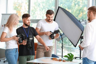 Stüdyoda genç fotoğrafçılara öğretmenlik yapıyor.