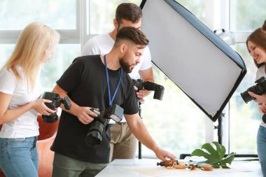 Stüdyoda genç fotoğrafçılara öğretmenlik yapıyor.