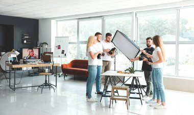 Stüdyoda genç fotoğrafçılara öğretmenlik yapıyor.