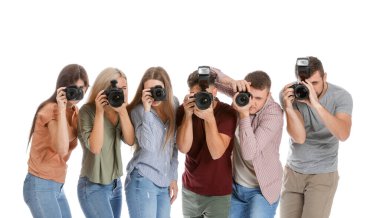 Beyaz arkaplanda bir grup genç fotoğrafçı