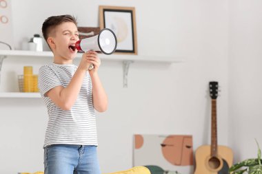 Evde megafonla bağıran küçük çocuk.