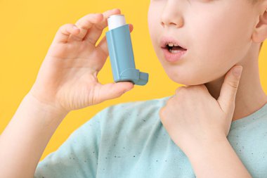 Astım spreyi olan küçük bir çocuk astım krizi geçiriyor.