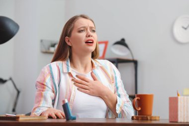 Evde astım krizi geçiren genç bir kadın.