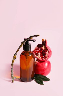Renkli arka planda doğal kozmetik yağı ve nar bileşimi