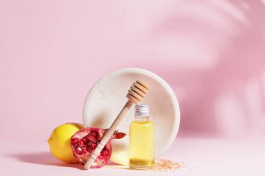 Renkli arka planda doğal kozmetik yağı, limon ve nar bileşimi