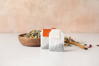 Çay poşetleri ve kuru otlar masada.