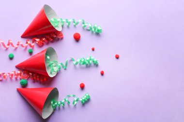 Renkli arka planda parti şapkaları olan kompozisyon