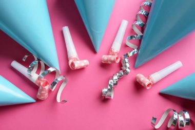 Renkli arka planda parti şapkaları olan kompozisyon