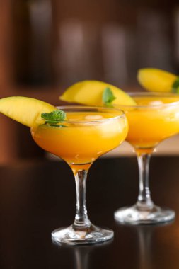 Bardaki masada bir bardak lezzetli mango margaritası.