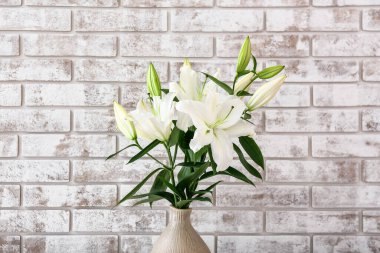 Tuğla duvarın yanında güzel zambak çiçekleri