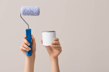 Renkli arka planda boya ve silindirli kadın elleri