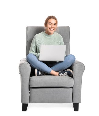 Dizüstü bilgisayarlı genç bir kadın beyaz arka planda koltukta oturuyor.