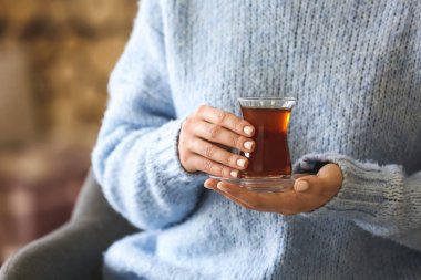 Bir fincan sıcak çay içen kadın, yakın plan.