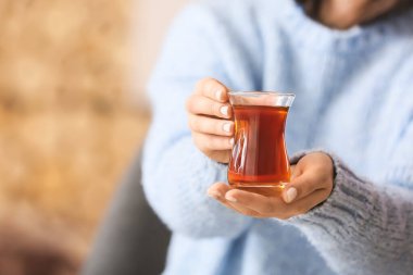 Bir fincan sıcak çay içen kadın, yakın plan.