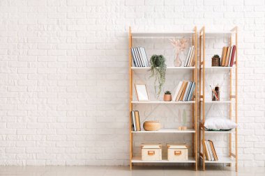 Modern raf üniteleri tuğla duvarın yanında