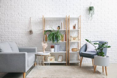 Rafları, kanepesi ve koltuğu olan modern bir oda.