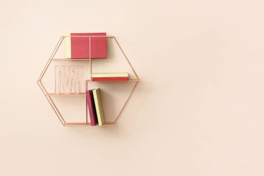 Renkli duvarda kitap asılı raflar