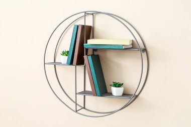 Renkli duvarda kitap ve ev bitkileri asılı raflar