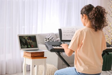 Evde müzik dersleri veren genç bir kadın.