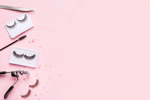 Composition with false eyelashes on color background