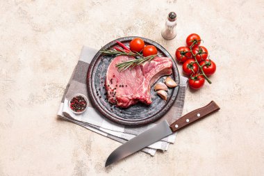 Hafif arka planda taze çiğ et ve baharatlı tabak.