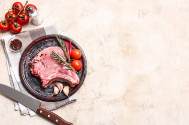 Hafif arka planda taze çiğ et ve baharatlı tabak.