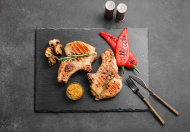 Siyah arka planda baharatlı lezzetli biftekler.