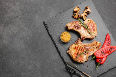 Siyah arka planda baharatlı lezzetli biftekler.