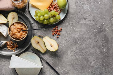 Farklı peynirli armut reçeli ve grunge arkaplanda fındık.