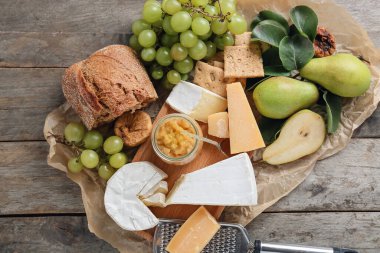 Farklı peynirli armut reçeli ve ahşap zemin üzerinde ekmek.