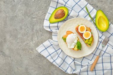 Gri arka planda lezzetli sandviçlerle dolu tabak.