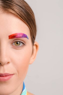 Gri arka planda yaratıcı kaşları olan güzel bir kadın. Yakın plan.