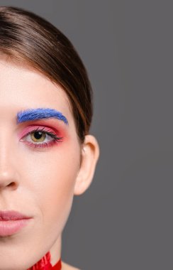 Gri arka planda olağandışı makyajı olan güzel bir kadın. Yakın plan.
