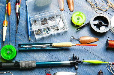 Renkli ahşap arka planda farklı balıkçılık ekipmanları