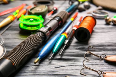 Koyu ahşap arka planda farklı balıkçılık ekipmanları, yakın plan.