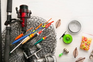 Hafif ahşap arka planda farklı balıkçılık ekipmanları