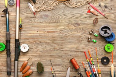 Ahşap arka planda farklı balıkçılık ekipmanlarından yapılmış çerçeve