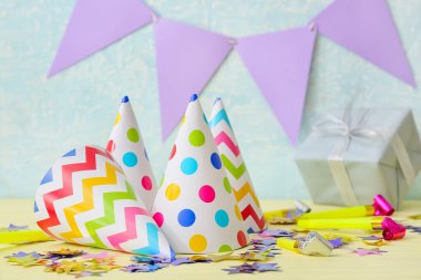 Renkli arka planda parti şapkaları olan kompozisyon