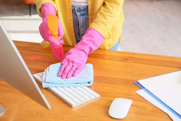 Young woman cleaning computer at home