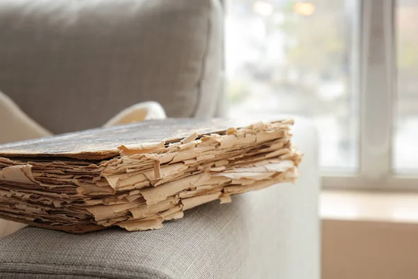 Old book on sofa in room, closeup