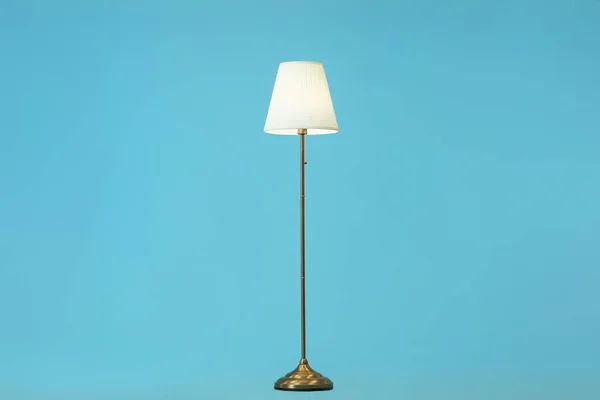 Stylish floor lamp on color background