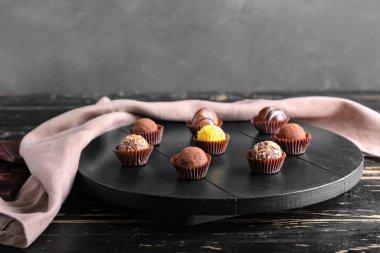 Tahta üzerinde tatlı çikolata şekerlemeleri olan tahta.