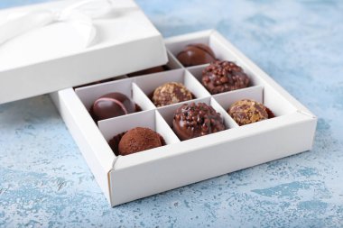 Renkli arkaplanda çikolata şekerli bir kutu