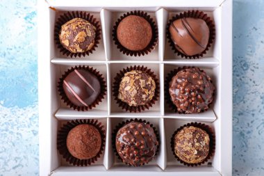 Renkli arkaplanda çikolata şekerli bir kutu