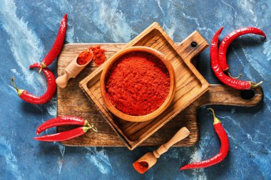 Arka planda kırmızı biber tozu ile kase ve kepçe