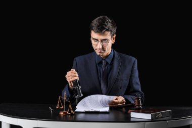 Masadaki siyah arka plandaki erkek yargıç.