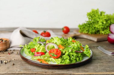 Ahşap arka planda sebzeli taze salata.