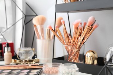 Makyaj fırçaları ve dekoratif kozmetik seti makyaj masasında.