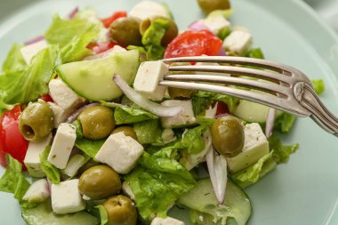 Taze Yunan salatası ve çatallı tabak, yakın plan.
